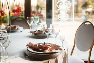 Close up festive table setting with empty wine glasses and pink napkin