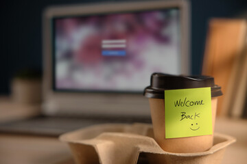 Back to Work Concept. Closeup of Welcome Note on Takeaway Coffee Cup in Office Desk. Message from a...