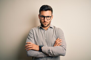 Young handsome man wearing elegant shirt and glasses over isolated white background skeptic and nervous, disapproving expression on face with crossed arms. Negative person.