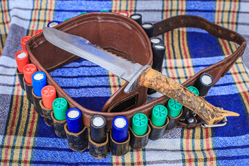 Hunting knife and cartridges for a hunting rifle in a bandoleer