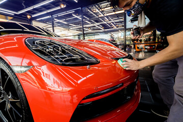 Car service worker applying nano coating on a car detail