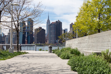 Fototapeta na wymiar Empty Walkway at Gantry Plaza State Park in Long Island City Queens New York with a view of the Midtown Manhattan Skyline during Spring