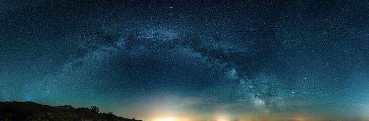 Scenic vivid panoramic landscape view of milky way over night sky