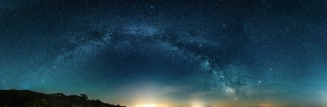 Scenic vivid panoramic landscape view of milky way over night sky