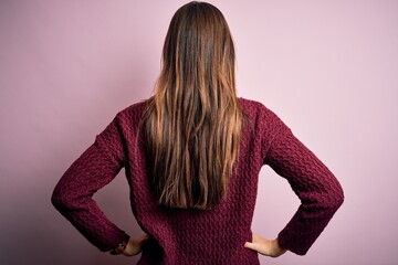 Young beautiful girl wearing casual sweater over isolated pink background standing backwards looking away with arms on body