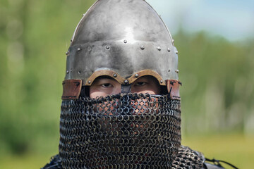 Close up face of asian warrior in eastern medieval helmet. A stern look.