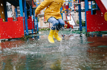 Unrecognizable toddler girl child wearing yellow rain boots