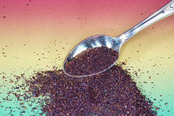 Sumac spice powder with macro lens photographed against colorful gradient in studio