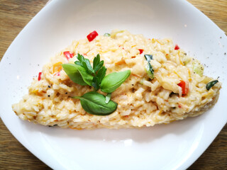 Tasty risotto with Shrimp, fresh herbs vegetables on a white plate