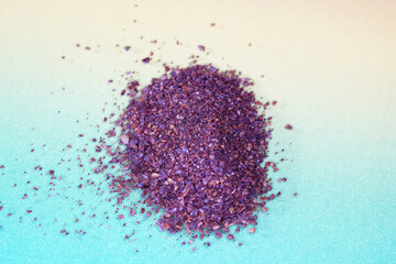 Sumac spice powder with macro lens photographed against colorful gradient in studio