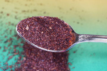 Sumac spice powder with macro lens photographed against colorful gradient in studio