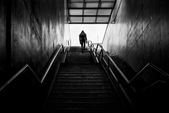 Pessoa solit&aacute;ria sobe escadaria de sa&iacute;da do metr&ocirc;