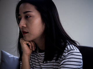 Close-up of an Asian woman feeling sad in a room. Look lonely and disappointed. Depression