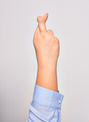 Hand of caucasian young woman doing lucky sign with crossed fingers over isolated white background