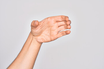 Hand of caucasian young man showing fingers over isolated white background holding invisible object, empty hand doing clipping and grabbing gesture