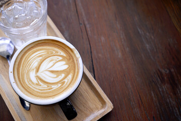 Hot late coffee in cup and ice water in glass on Coaster tray, copy space at right           