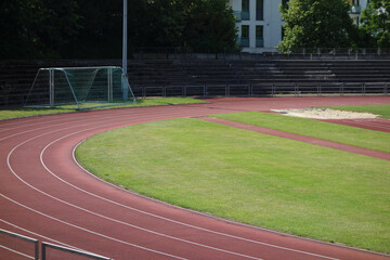 Tartanbahn eines Sportstadions mit wenigen Menschen aufgrund von Corona