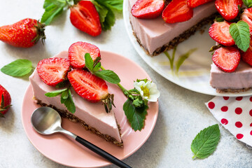 Summer diet dessert, cheesecake without baking. Strawberry cheesecake on a chocolate granola with fresh strawberries on a light gray table top.