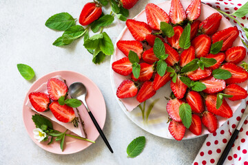 Summer diet dessert, cheesecake without baking. Strawberry cheesecake on a chocolate granola with fresh strawberries on a light gray table top. Top view flat lay background.