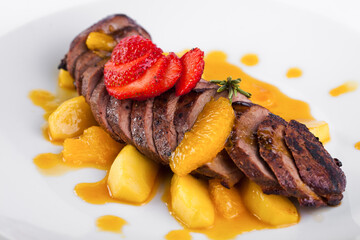 Baked meat in tangerine sauce with strawberry