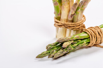 Green and white fresh asparagus on a gray background