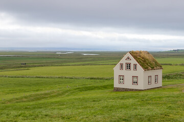 In der Landschaft, die nahezu unendlich scheint, stehen vereinzelt Häuser, Varmahlíð,...
