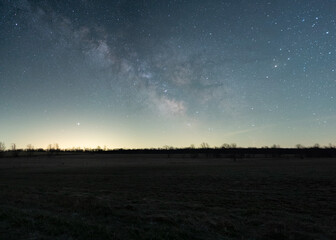 Obraz na płótnie Canvas The Milky Way Rises Over A Farm Field