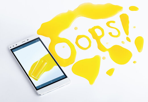 Oops. The juice spilled on the smartphone photo spreads across the table. Letters from the juice. Surprise. Colored image, photo.