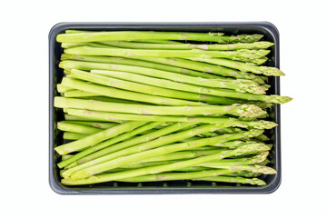 Fresh raw sprouts of green asparagus in a box isolated on white background. Close up