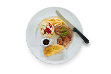 Steak pork tenderloin and side dishes in a white plate isolated on white background.