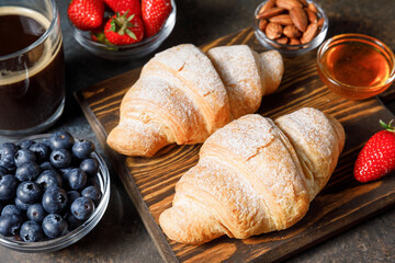 Breakfast with fresh croissants and berries on dark table background
