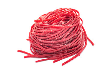 Fresh organic uncooked spaghetti pasta with beetroot rolled in a nest isolated on a white background