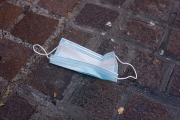 Closeup of used medical mask abandoned in the street during the Covid-19 pandemic