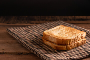 Tow slices of toast bread on a dark wooden background table.