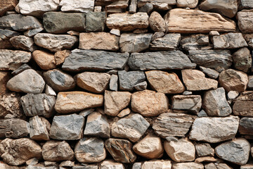 Wall of stones in China. Dry masonry.The background is a folded stone wall.