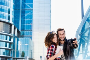 Portrait of young attractive couple taking selfie in the middle of the city
