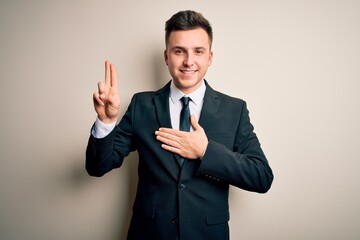 Young handsome business man wearing elegant suit and tie over isolated background smiling swearing...