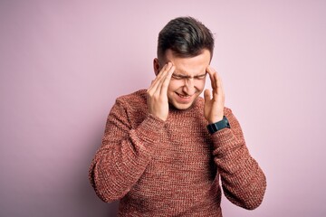 Young handsome caucasian man wearing casual winter sweater over pink isolated background with hand on headache because stress. Suffering migraine.