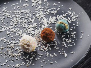 Little round coconut, truffle candys on the blue plate