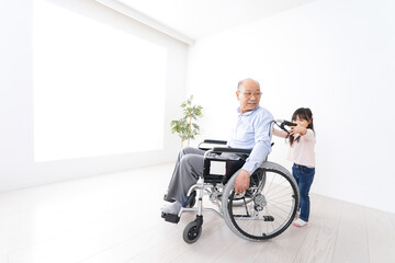 Fototapeta na wymiar 車椅子に乗る高齢男性と女の子