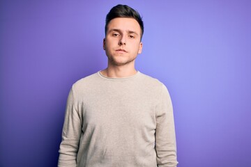 Young handsome caucasian man wearing casual sweater over purple isolated background Relaxed with serious expression on face. Simple and natural looking at the camera.