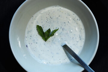 Photography of white sauce in a ceramic bowl on slate background for food illustrations