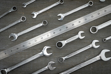 Set of tools for repair wrenches and ruler on a wooden background.