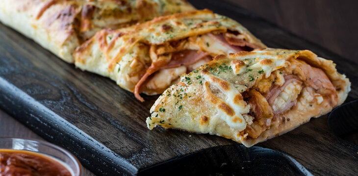 A Close Up View Of Stromboli Fresh Out Of The Oven And Sliced Ready For Eating.