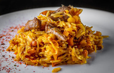 Rice with Vegetables and Meat in white plate on black wooden table background