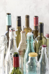 A close up of several different types and sizes of bottles against a bright background.