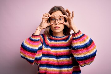 Young beautiful blonde girl wearing glasses and casual sweater over pink isolated background Trying to open eyes with fingers, sleepy and tired for morning fatigue