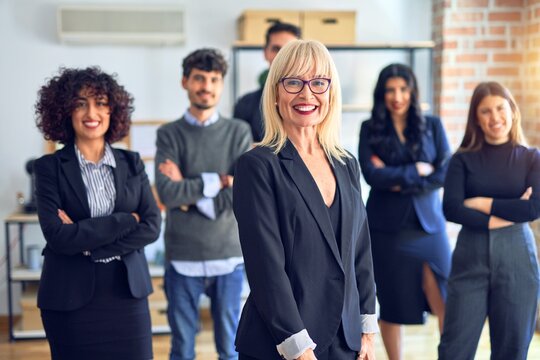 Group of business workers smiling happy and confident. Posing together looking at the camera, middle age beautiful woman with smile on face at the office