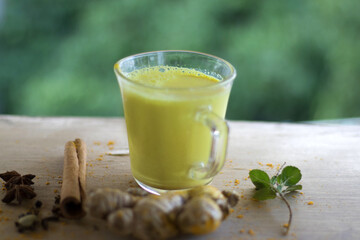 Turmeric golden milk in a cup with ginger, cinnamon,blackpepper and turmeric powder