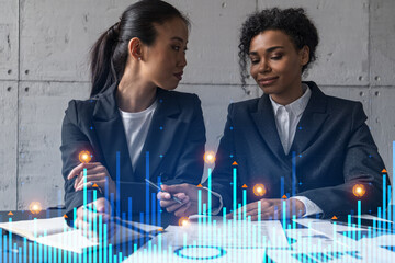Two businesswomen work together in modern office on new project. Double exposure. Concept of success. Financial graph.